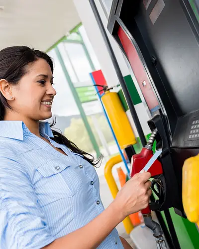 Woman pays for gas at pumps
