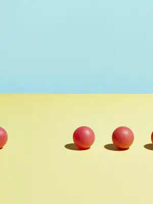 Illustration of a row of red balls on a yellow and blue background. One ball is missing from the row.