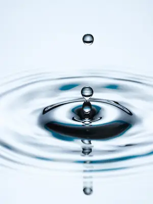 Photo of droplets of water falling into a pool of water