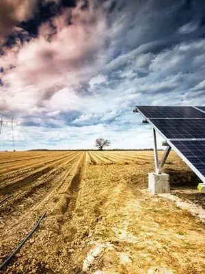 Photo of solar array next to dry field with irrigation hoses