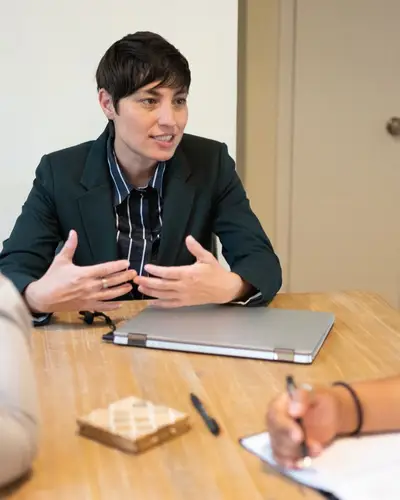 Photo of three people having a meeting in a conference room.