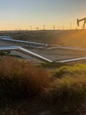 A pipeline runs across oil fields.