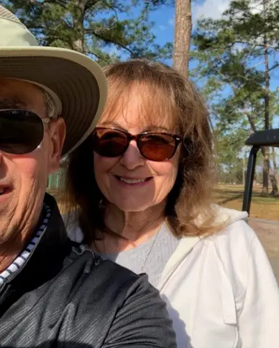Cancer survivor Michael and his wife Bobbie pose for a photo in front of their golf cart.