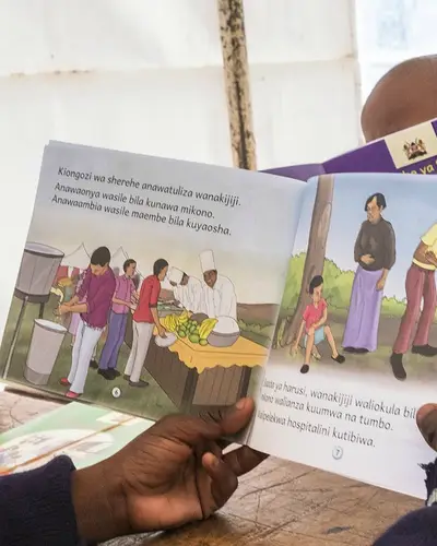 Children read books produced by RTI for international literacy programs.