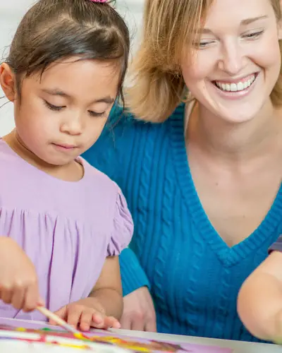 Preschool children paint with a teacher