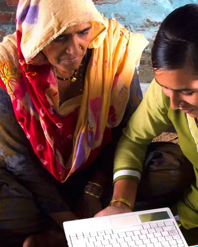 A daughter and mother look at a laptop