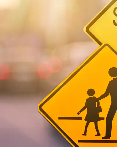 Various yellow street signs that are used to caution drivers that they have entered a school zone