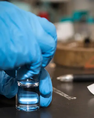 close-up of a research chemist holding a vial
