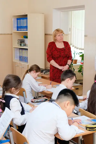 Photo of a teacher and her class in Kyrgyz Republic.