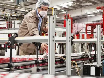 Man standing over manufacturing equipment
