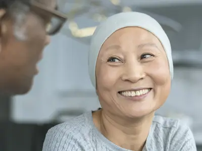 A cancer patient smiles at her doctor.