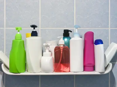 Shampoo and soap bottles on shower shelf