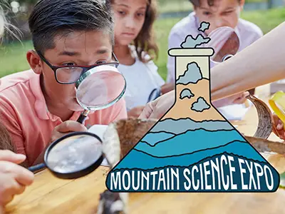 A child looking at something with a magnifying glass. What he's looking at is covered by a graphic of a beaker that says "Mountain Science Expo"