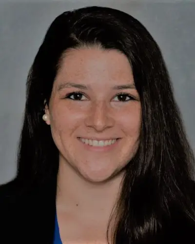 Headshot of Allyson Corbo smiling against a grey background