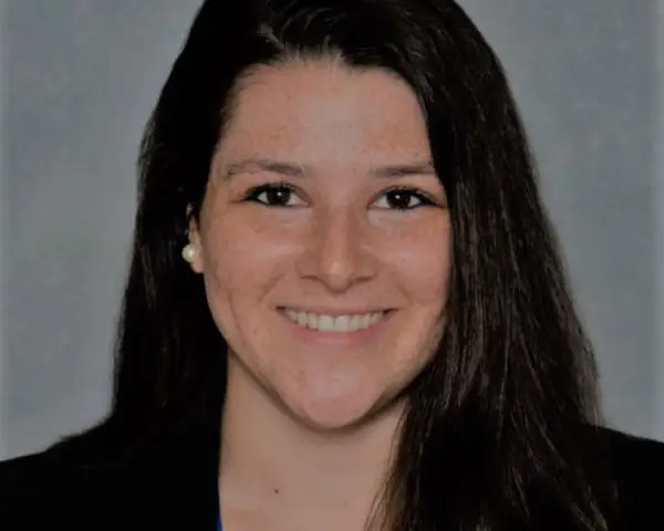 Headshot of Allyson Corbo smiling against a grey background