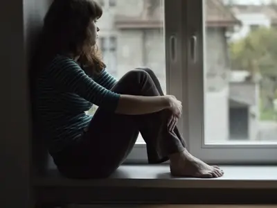 woman looks out window