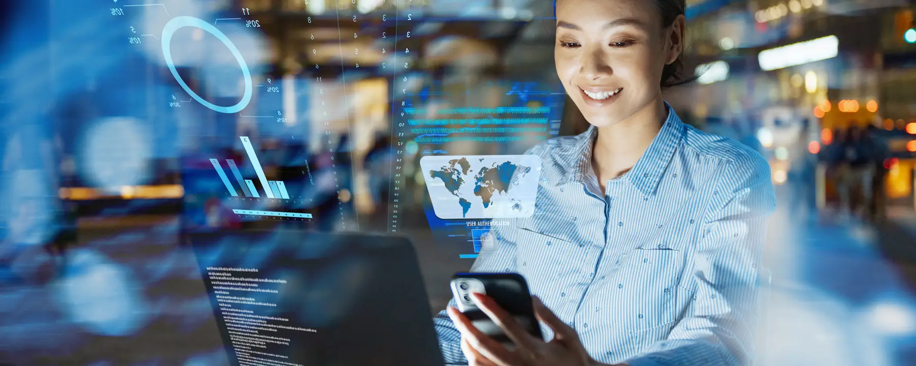 Woman looking at phone and laptop