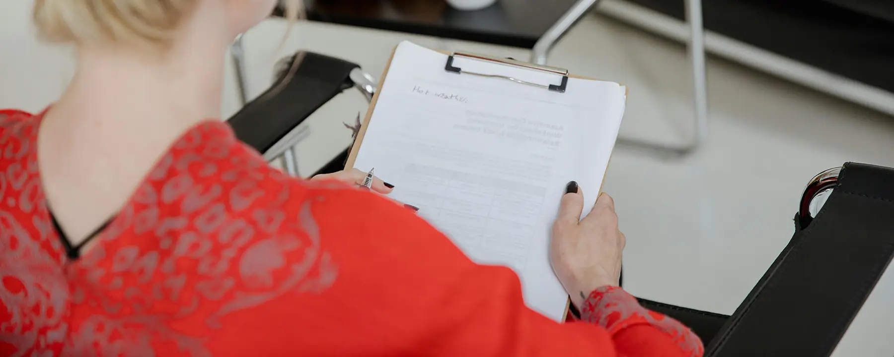 An image of a woman holding a clipboard with a filled out form