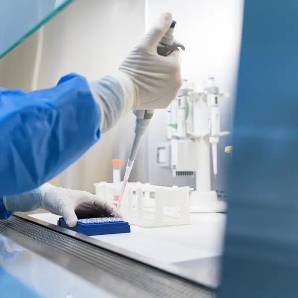 Image of researcher in a lab using a pipette.