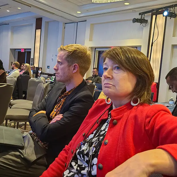 Adam Preston and Eileen Reynolds attend a session at the 2022 DHIS2 Symposium.