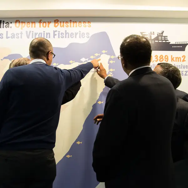 Seafood industry leaders check out a map of Somalia's fisheries.