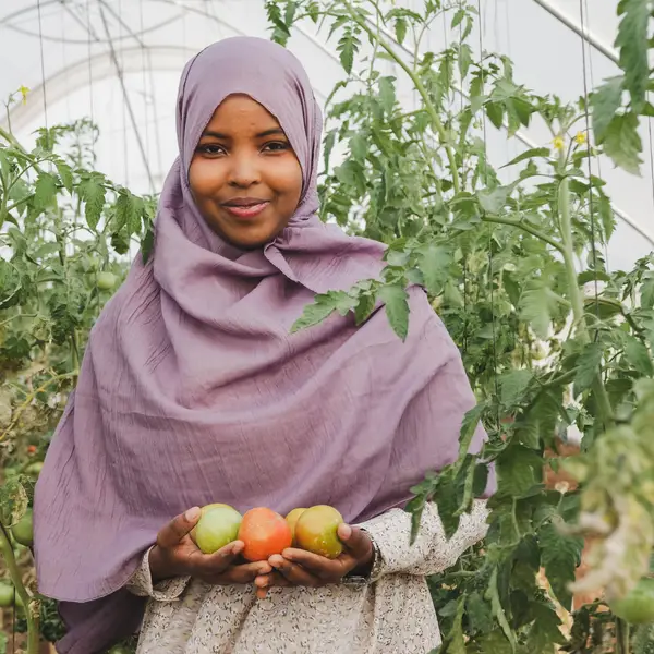 A Somali girl holds samples of fruit from an orchard.