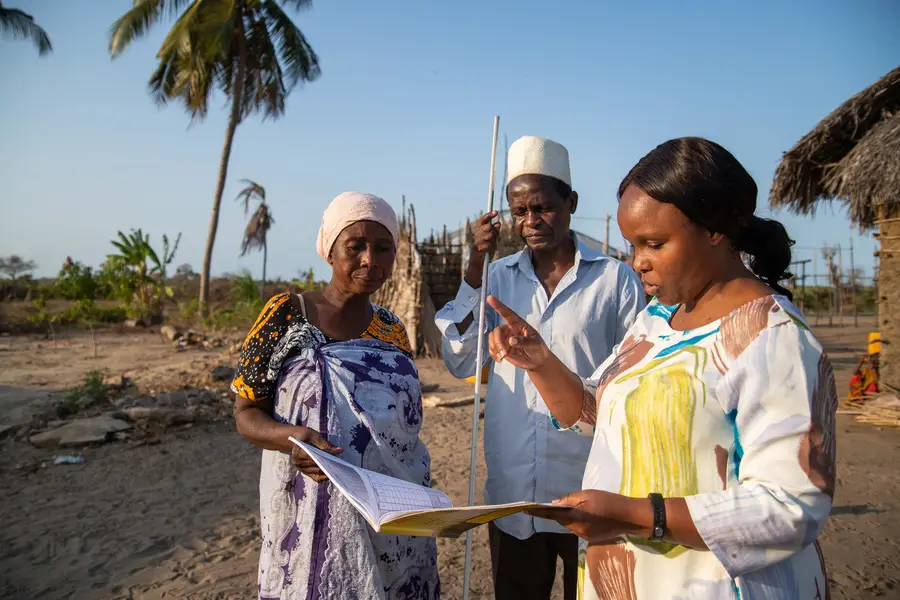 Dr. Faraja Lyamuya, LF Focal Person for the Ministry of Health in Tanzania, consulting with community health workers during a LF treatment campaign in Kilwa District, Tanzania