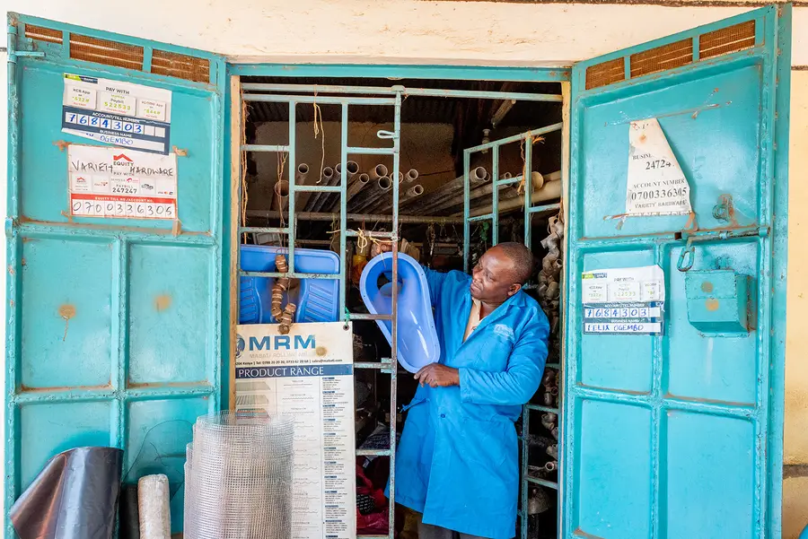 A sanitation worker in Kenya demonstrates equipment.