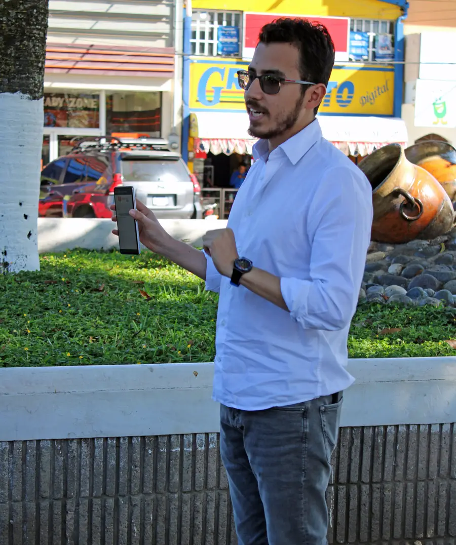 Photo of Diego Aguirre standing outside holding his phone