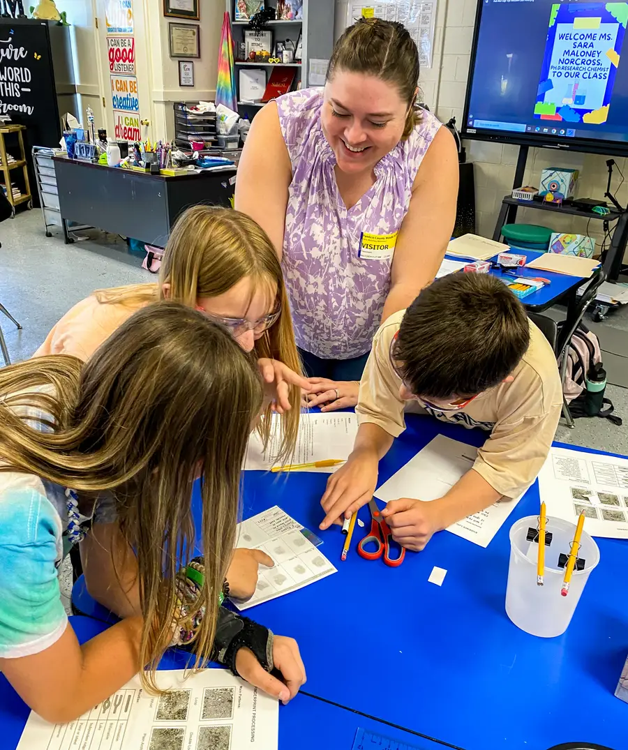 Sara Maloney Norcross works with students on forensics fingerprinting activity