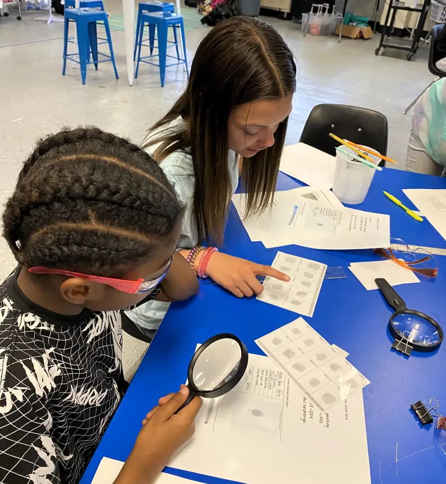 Two students study papers to solve a mystery