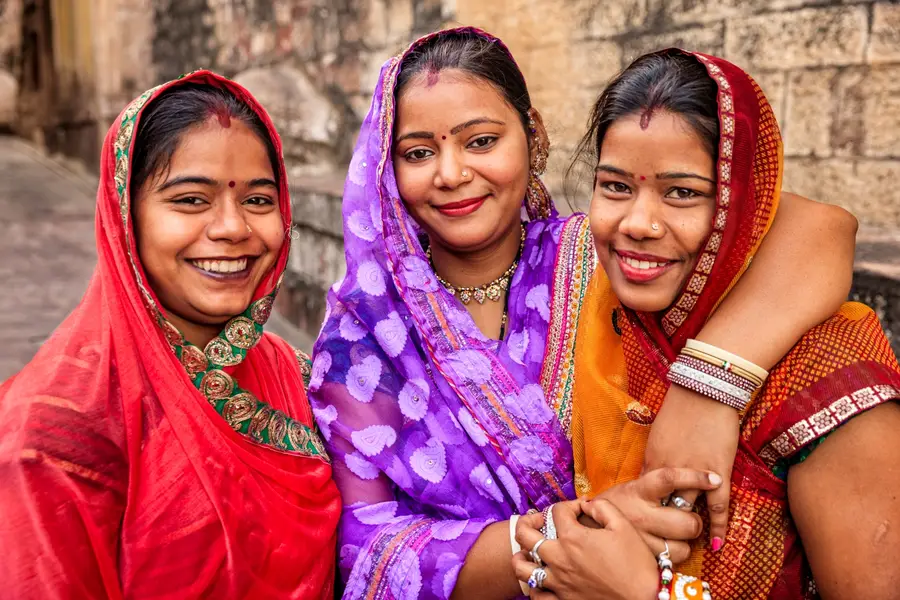 Photo of three young Indian women smiling outside