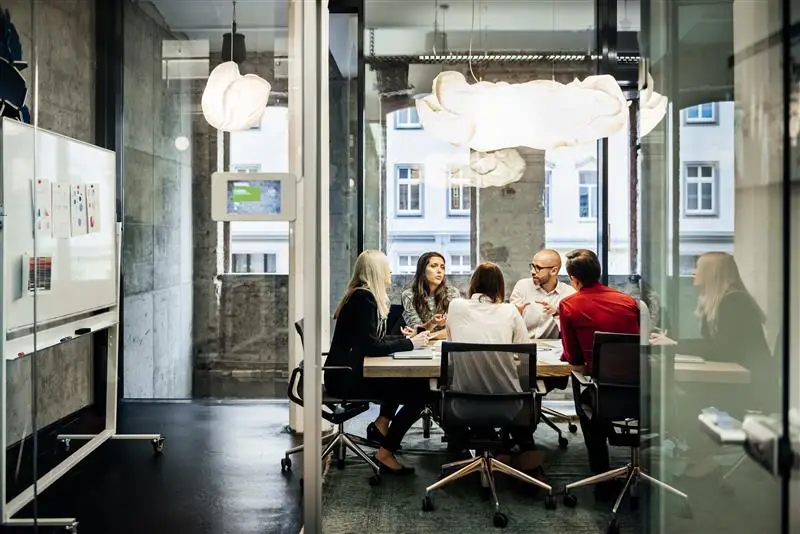 Group of business people sitting around a desk.