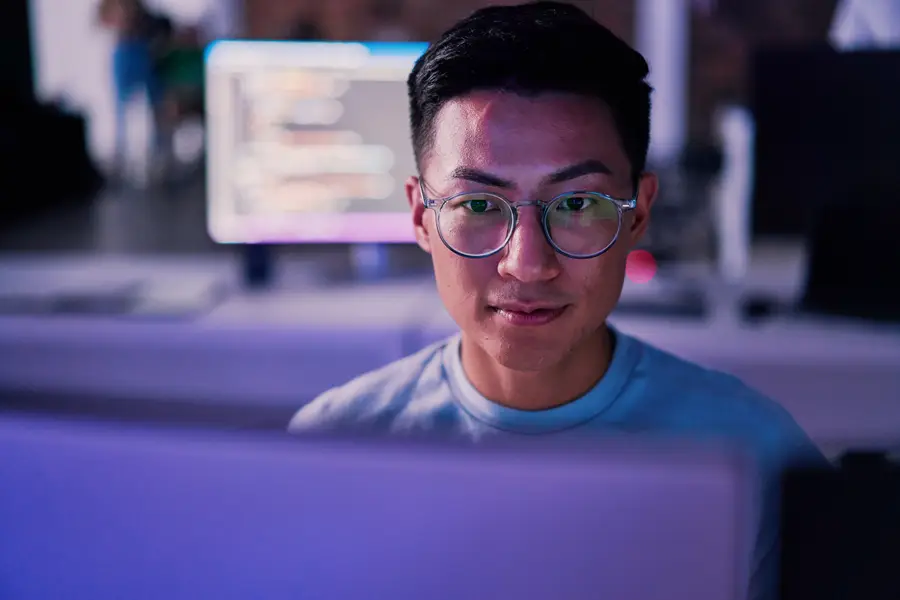 Male coder looking at code on computer