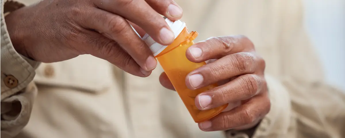 Older man opening prescription drug bottle