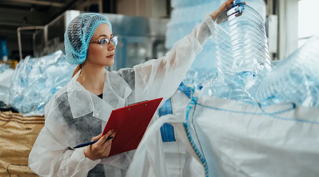A woman inspects an empty plastic container.