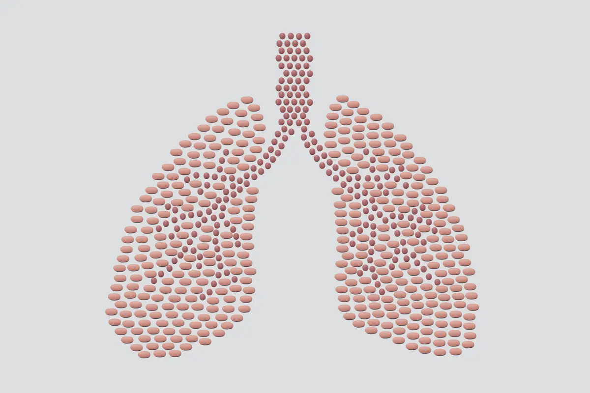 Illustration of pills in the shape of a human lungs.