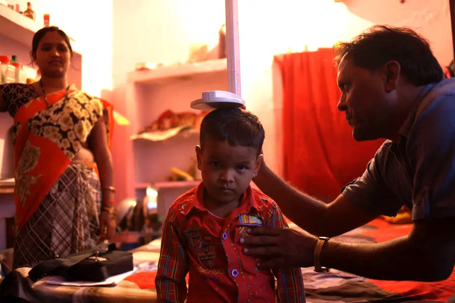 An Indian boy has his height measured during a health visit.