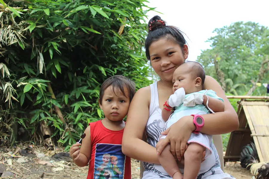 A teen mother and her children in the Philippines.