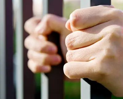 Hands on jail bars