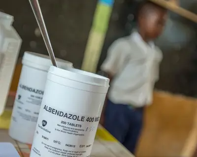 health worker measures a child to determine the right dose of an NTD medication