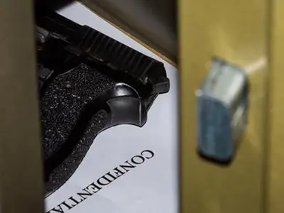 Gun in a safe. Safe door is partially open