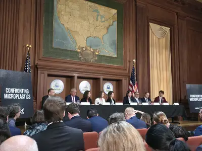 Microplastics event with people sitting on a stage with a table