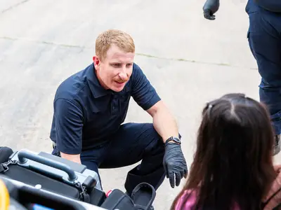 A paramedic assists a women. 