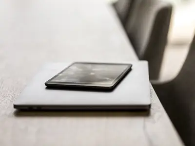 A laptop and a tablet sitting on a table
