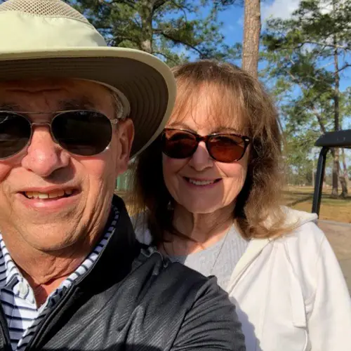 Cancer survivor Michael and his wife Bobbie pose for a photo in front of their golf cart.