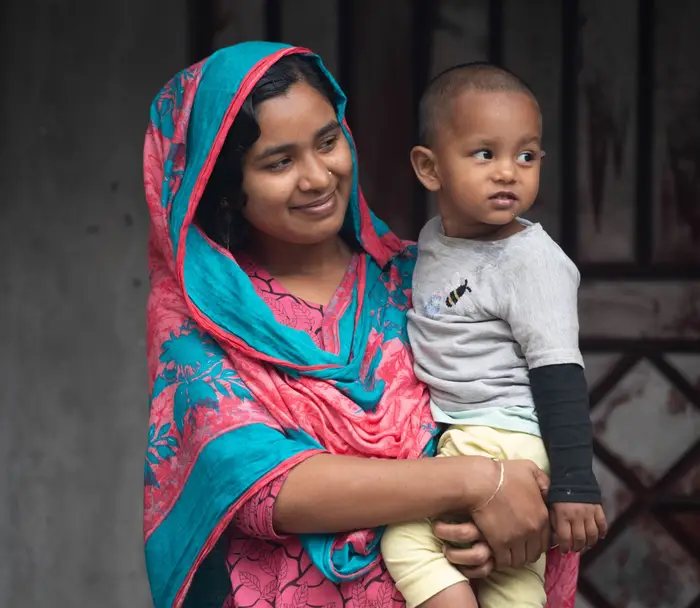 Photo of a Bangladeshi mother holding her child and smiling