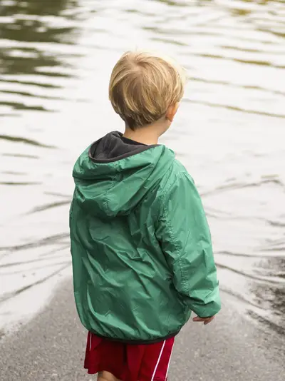 Little boy looking at big puddle of water