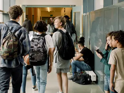 A group of middle school-aged children walking in a school hallway