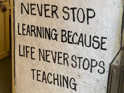 A painted sign that says "Never Stop Learning Because Life Never Stops Teaching."